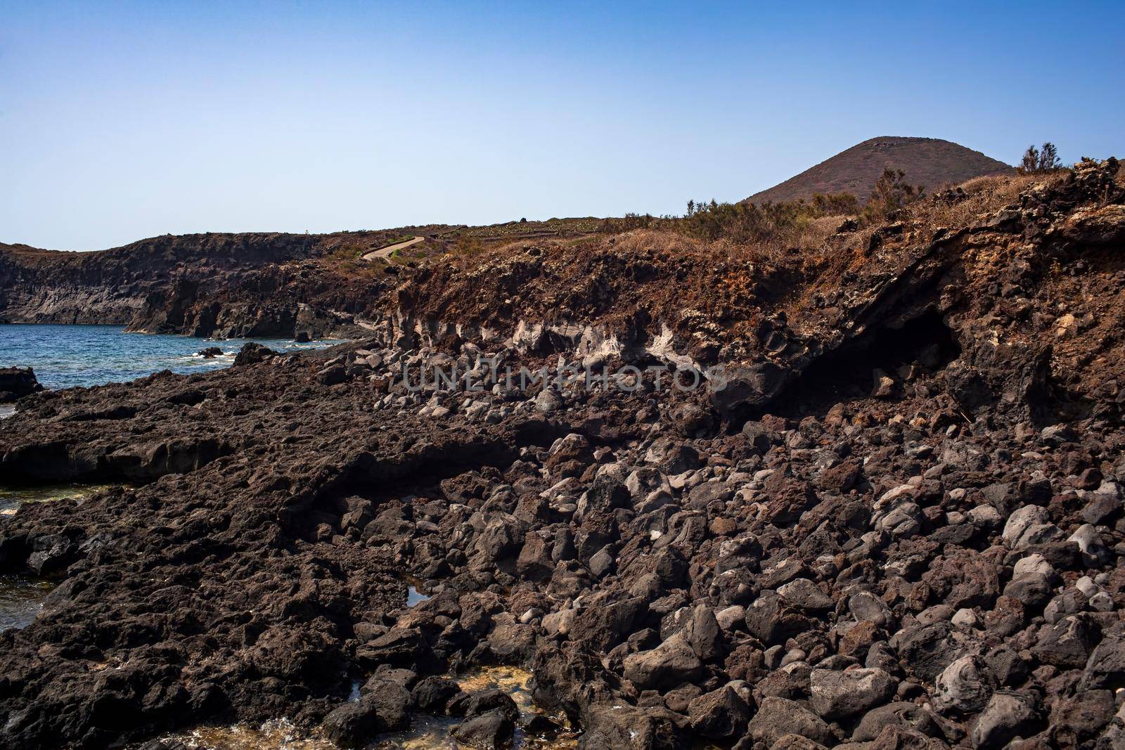 View of the scenic lava rock cliff in the Linosa island. by bepsimage