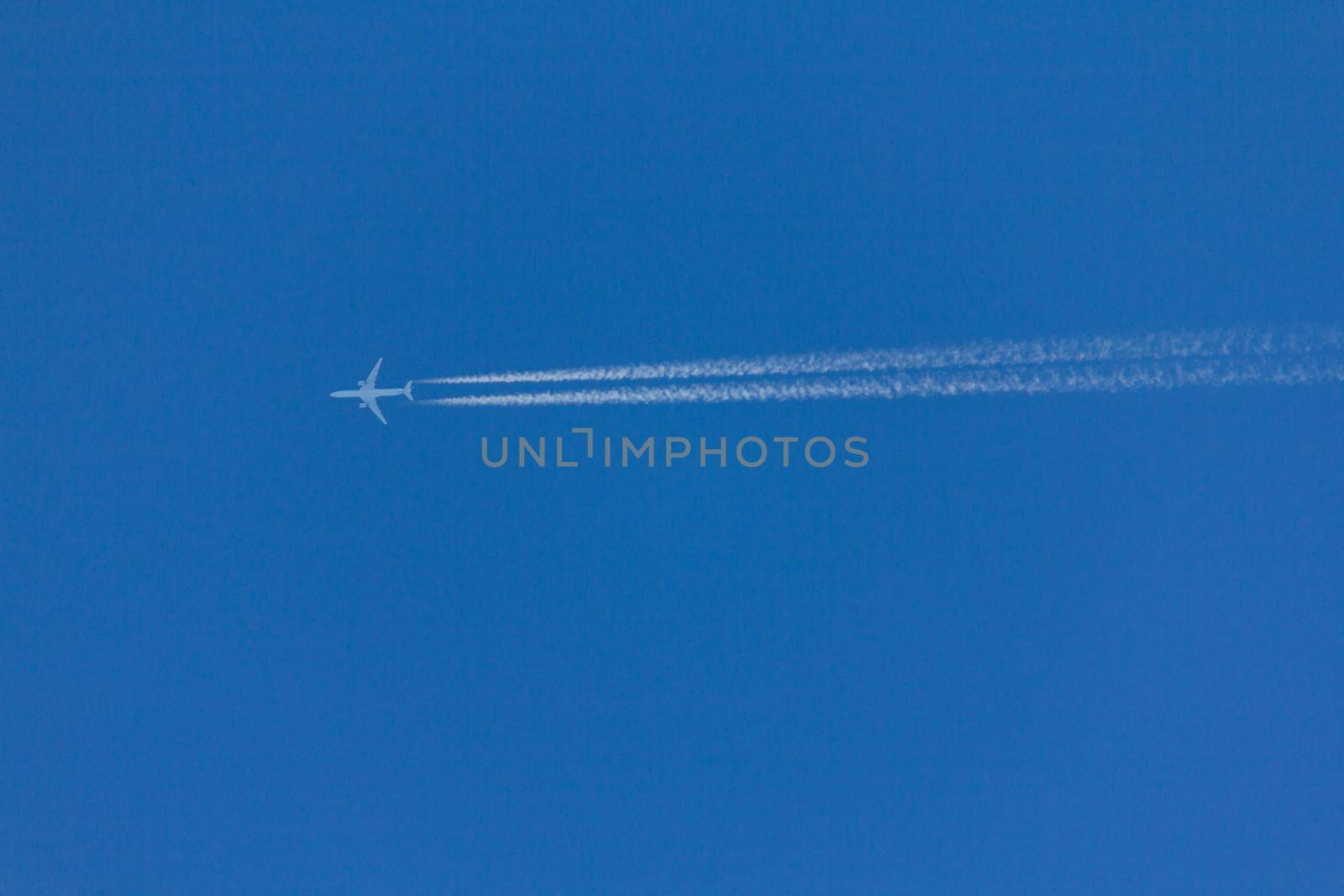 Flying plane leaves an inversion trail in the air by SorokinNikita