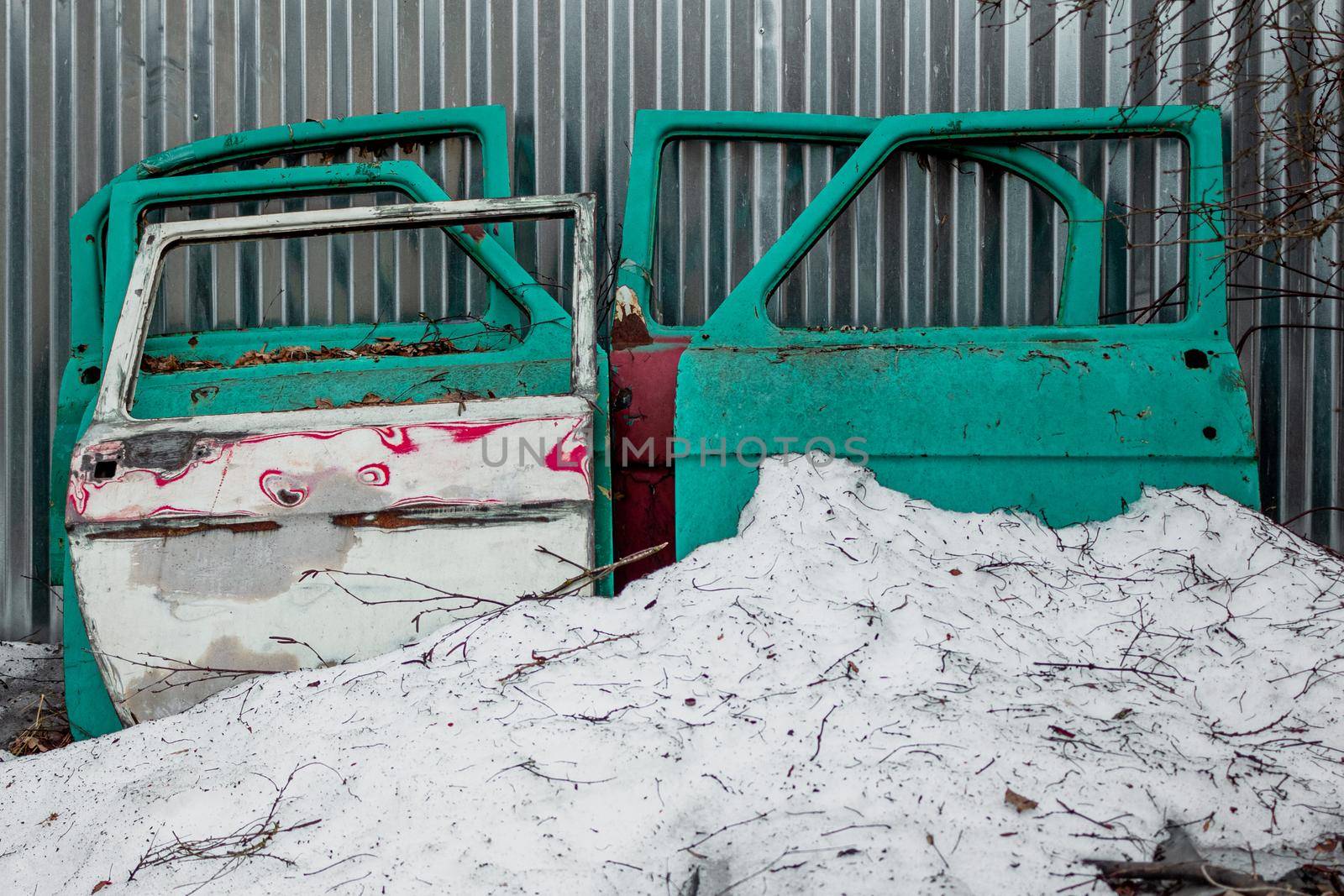 A pile of metal junk in a snow next to a fence by SorokinNikita