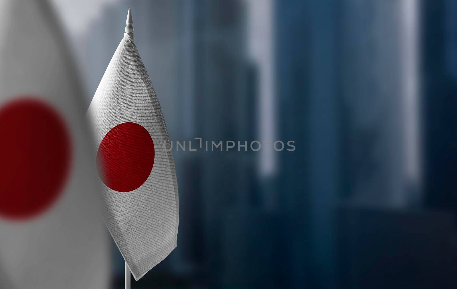Small flags of Japan on a blurry background of the city.