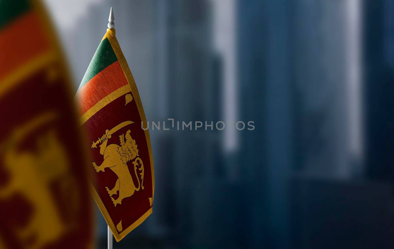 Small flags of Sri Lanka on a blurry background of the city.