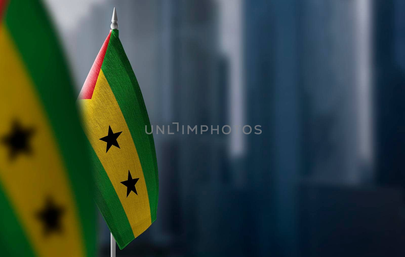 Small flags of Sao Tome and Principe on a blurry background of the city.