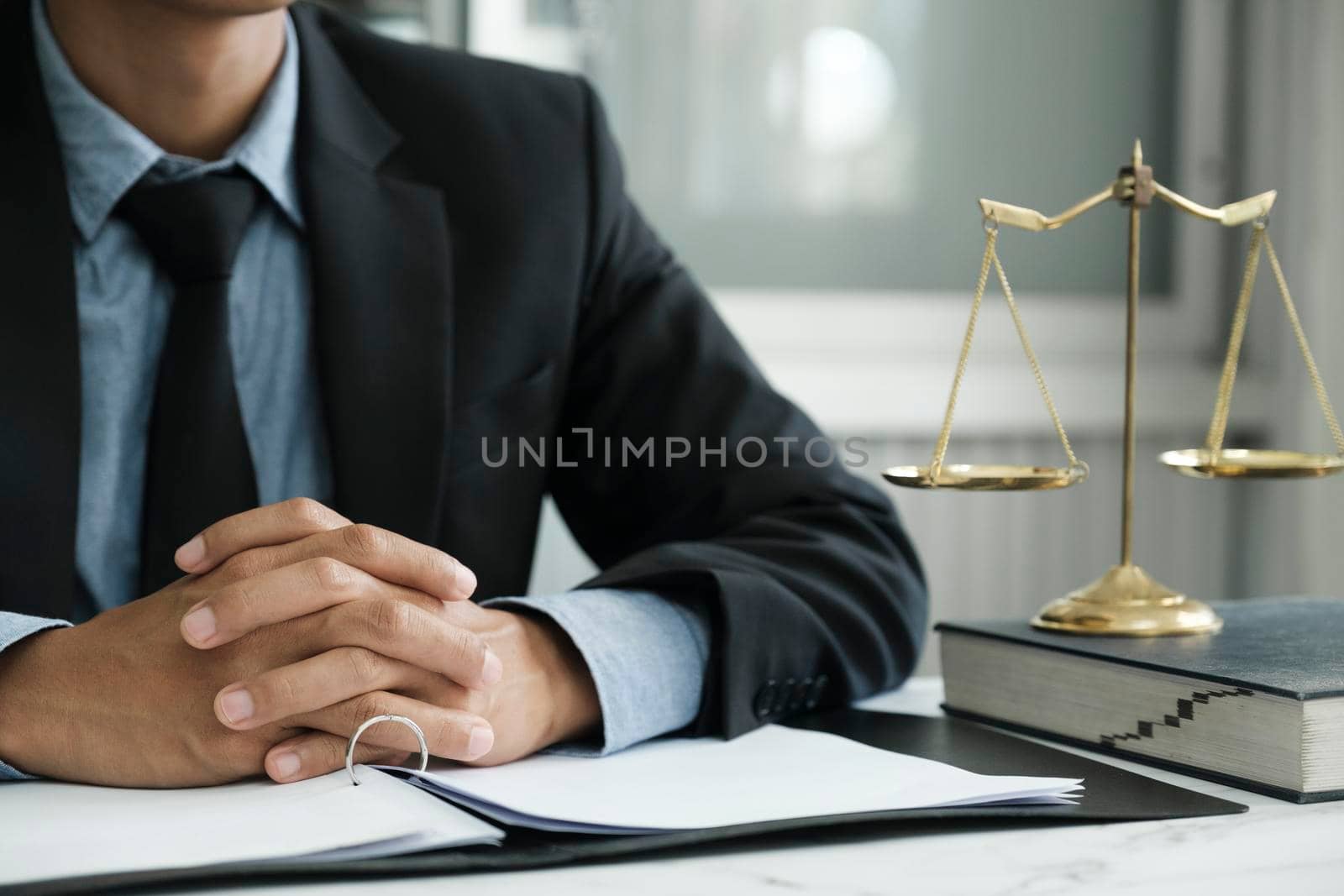 Law, legal services, advice, justice and law concept. Male lawyer in the office with brass scale. 
