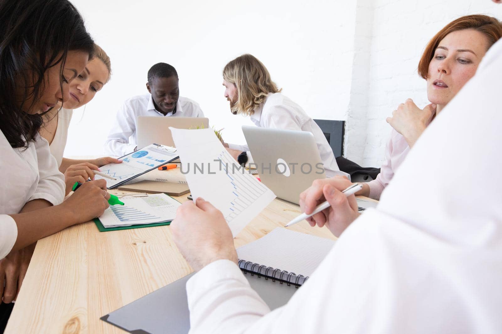 Confident businessmen and businesswomen sitting and working. Business people sitting around the desk in a meeting