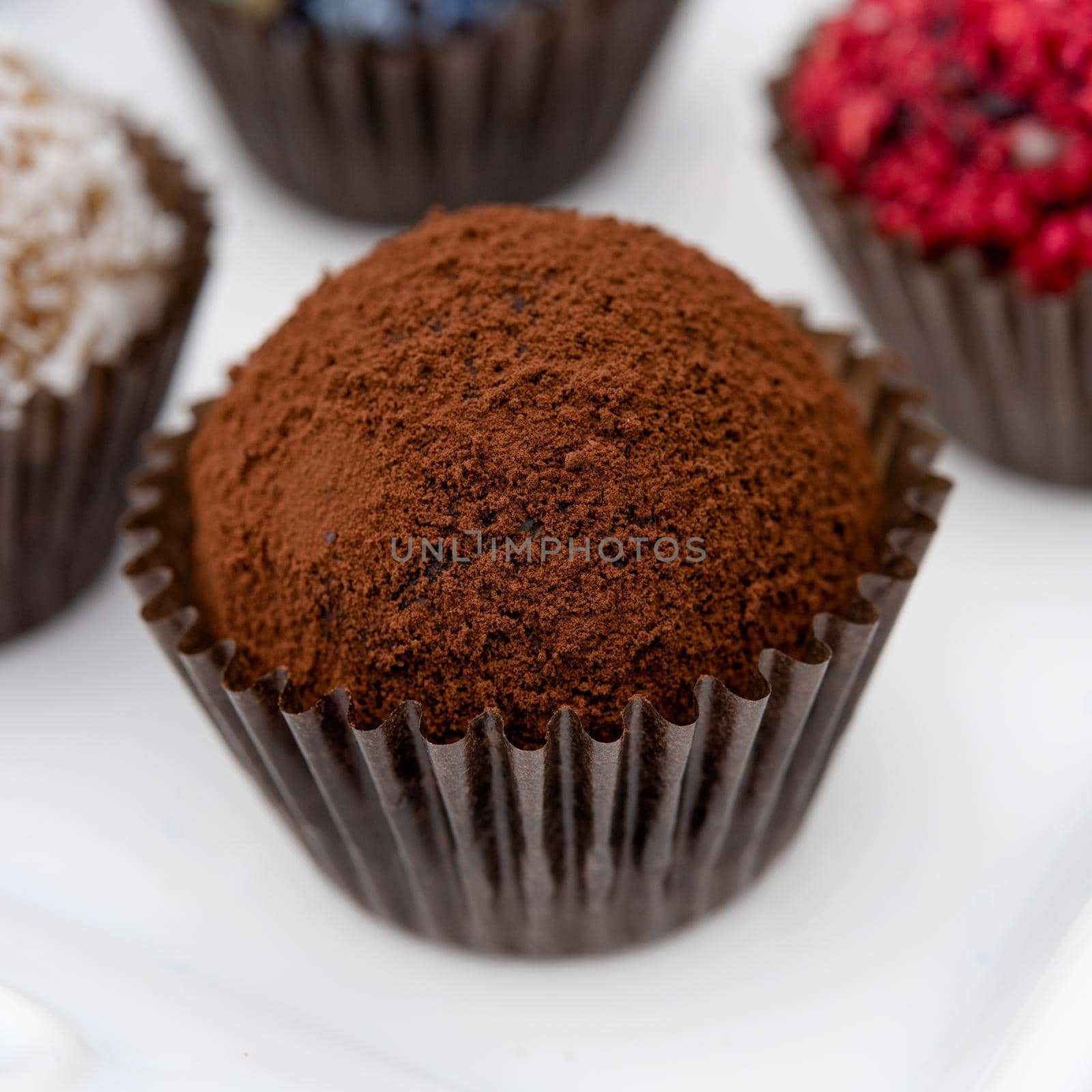 close up of chocolate sweet balls on white background