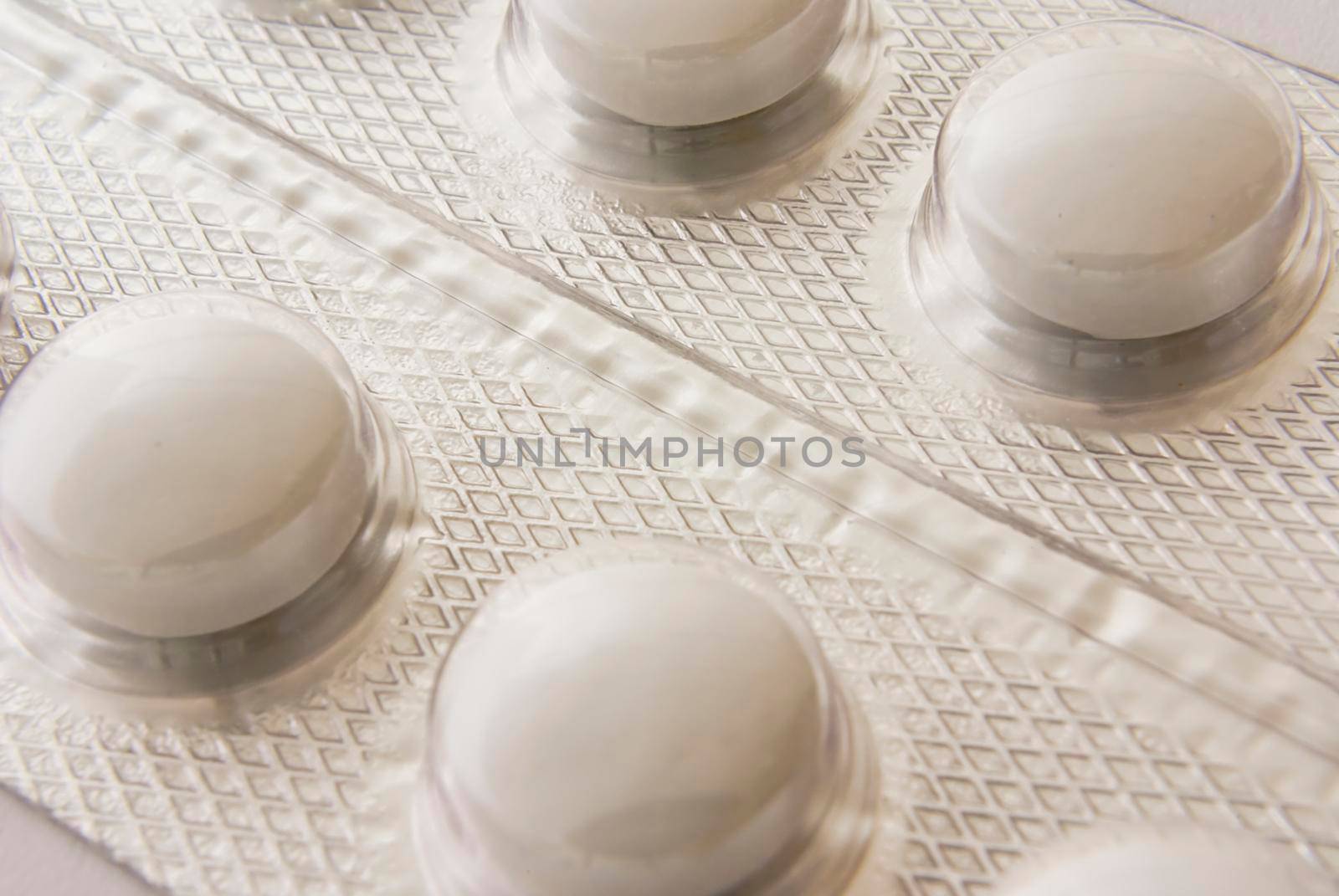 Some white round pills in a metallic blister