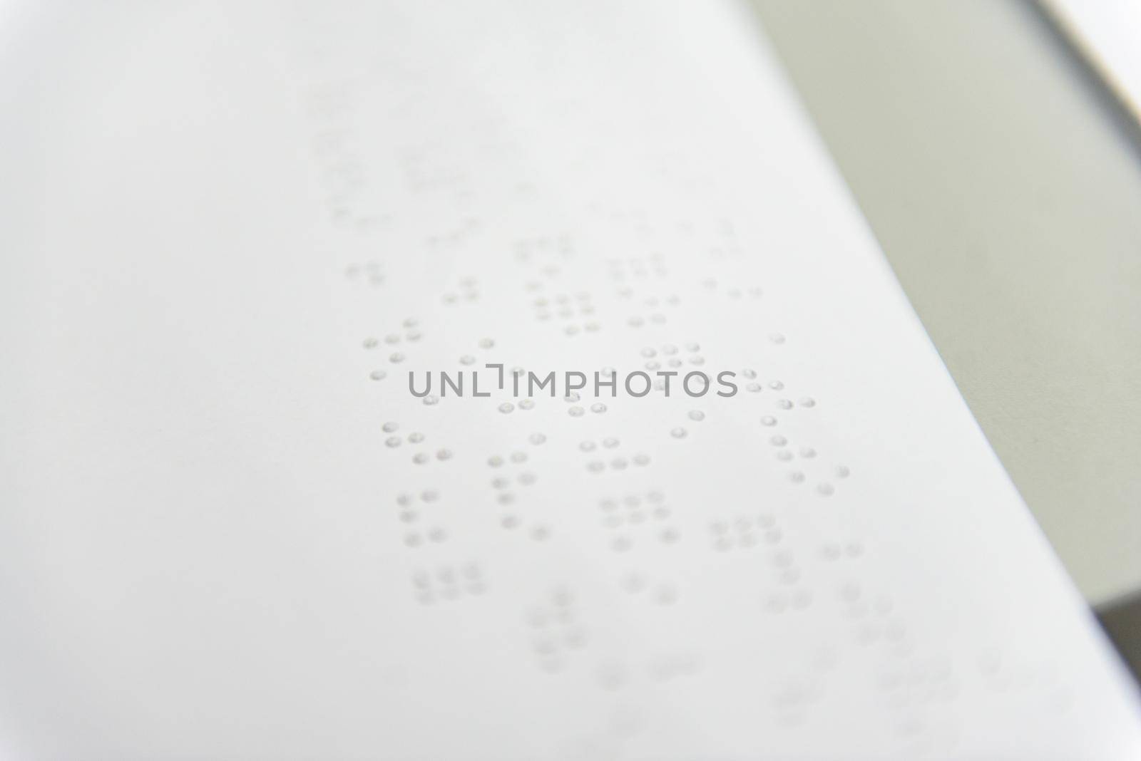 A fragment of text in Louis Braille printed on a standard sheet of paper using special printing equipment.