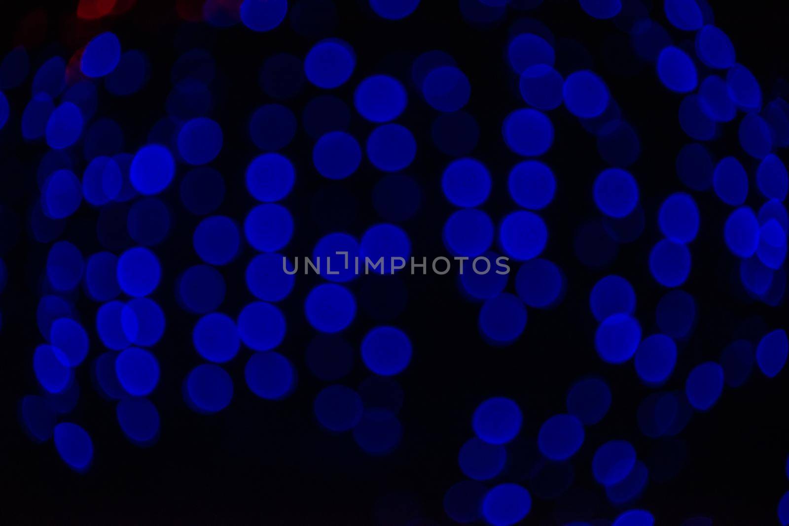 Group of blue holiday lights on dark background of night.