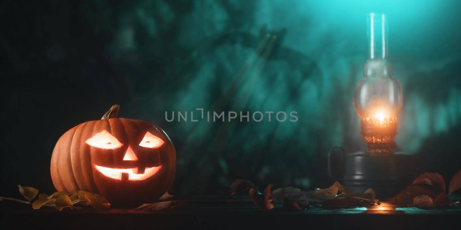 Halloween pumpkin head jack lantern with glowing eyes and kerosene lamp on wooden table by galsand