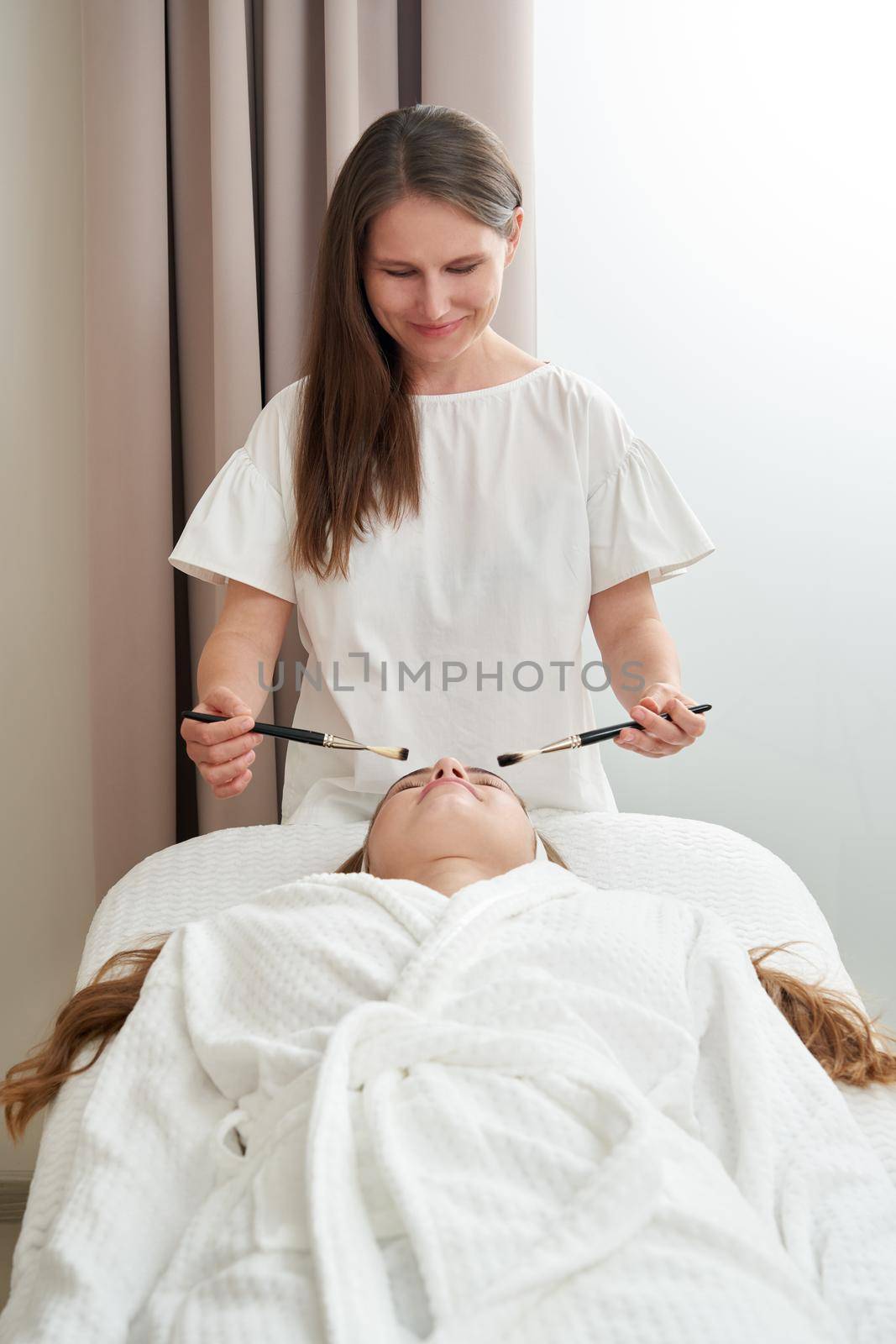 Woman Gets Brushes Treatment At Beauty Clinic. Face Skin Care concept. Relaxing in spa salon by Mariakray