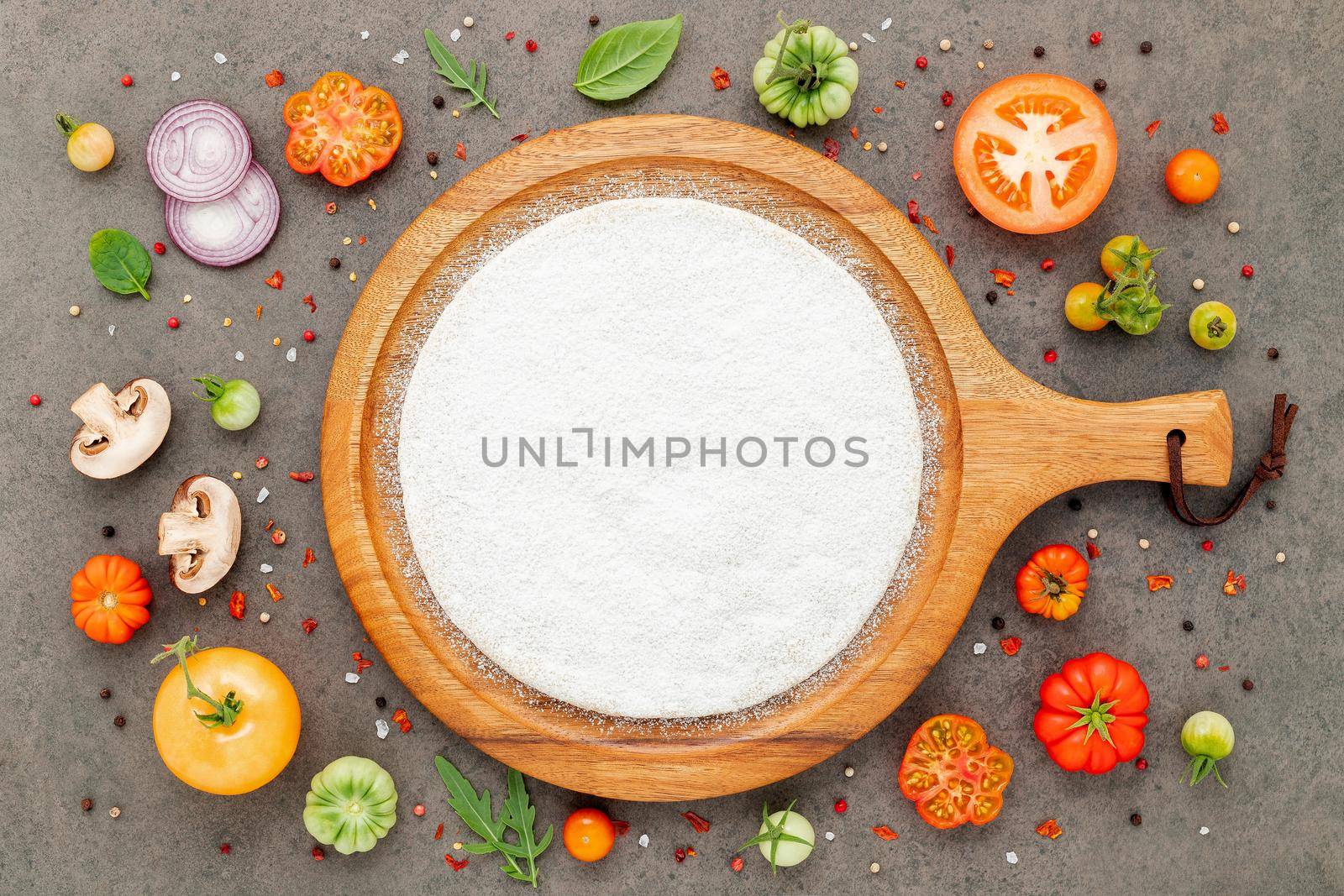 The ingredients for homemade pizza set up on dark stone background. by kerdkanno