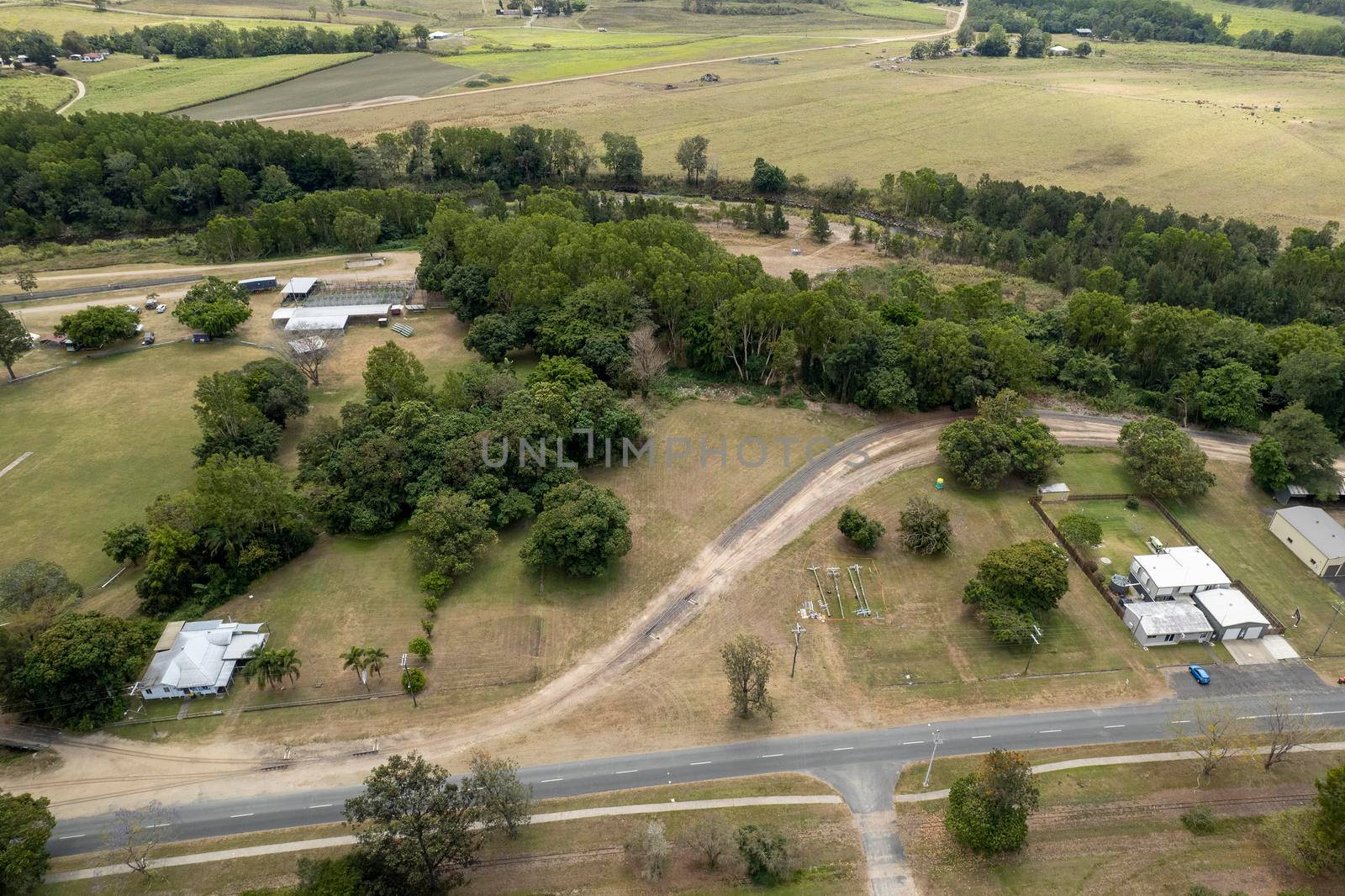 Aerial perspective of small township showing cattle yards, show ring and homes bordered by a creek and the highway. Finch Hatton, Queensland, Australia.