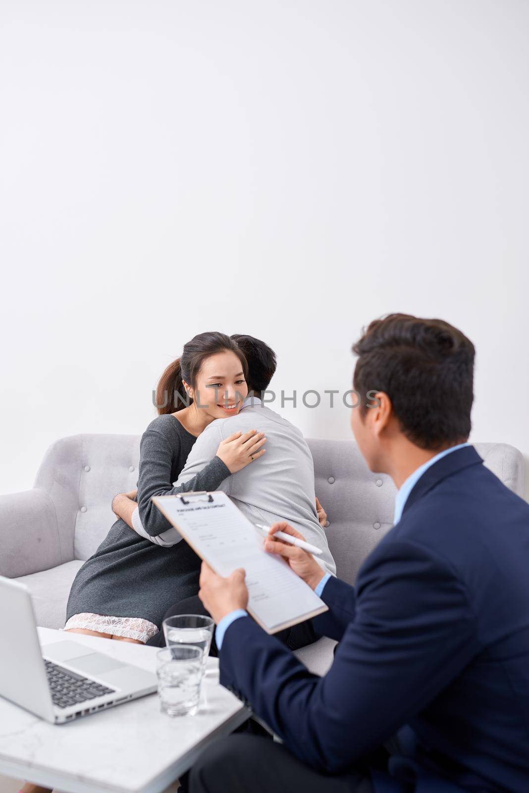 Happy young couple hold each otherâ??s hands listening to female agent, planning wedding, consulting investment advisor, hearing good news, casual marriage registration, buying real estate