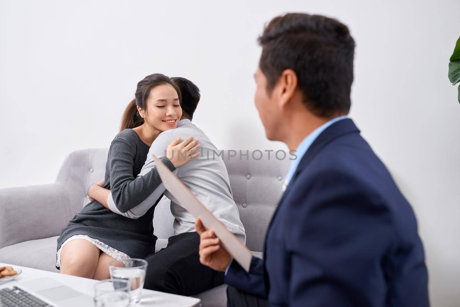 Happy young couple hold each other hands listening to female agent, planning wedding, consulting investment advisor, hearing good news, casual marriage registration, buying real estate