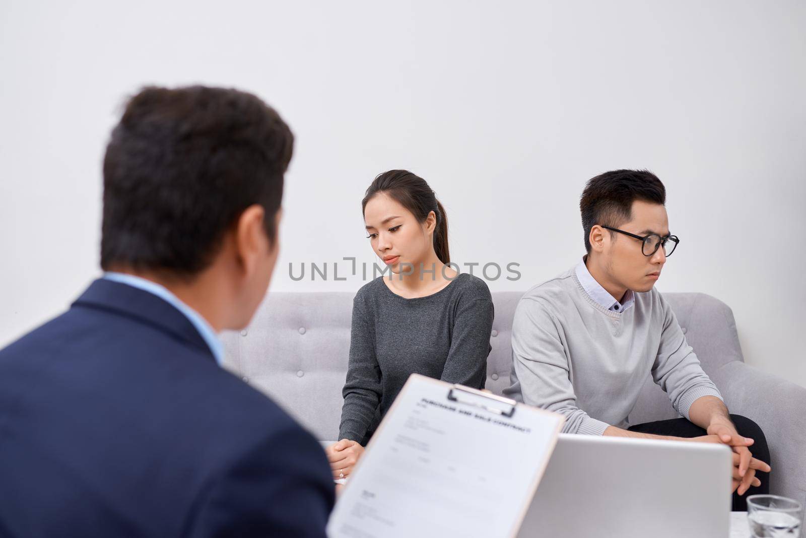 Young angry couple of cheated investors holding papers arguing with male real estate agent, defrauded property purchasers protecting their rights, too high interest rate of banking loan or mortgage by makidotvn