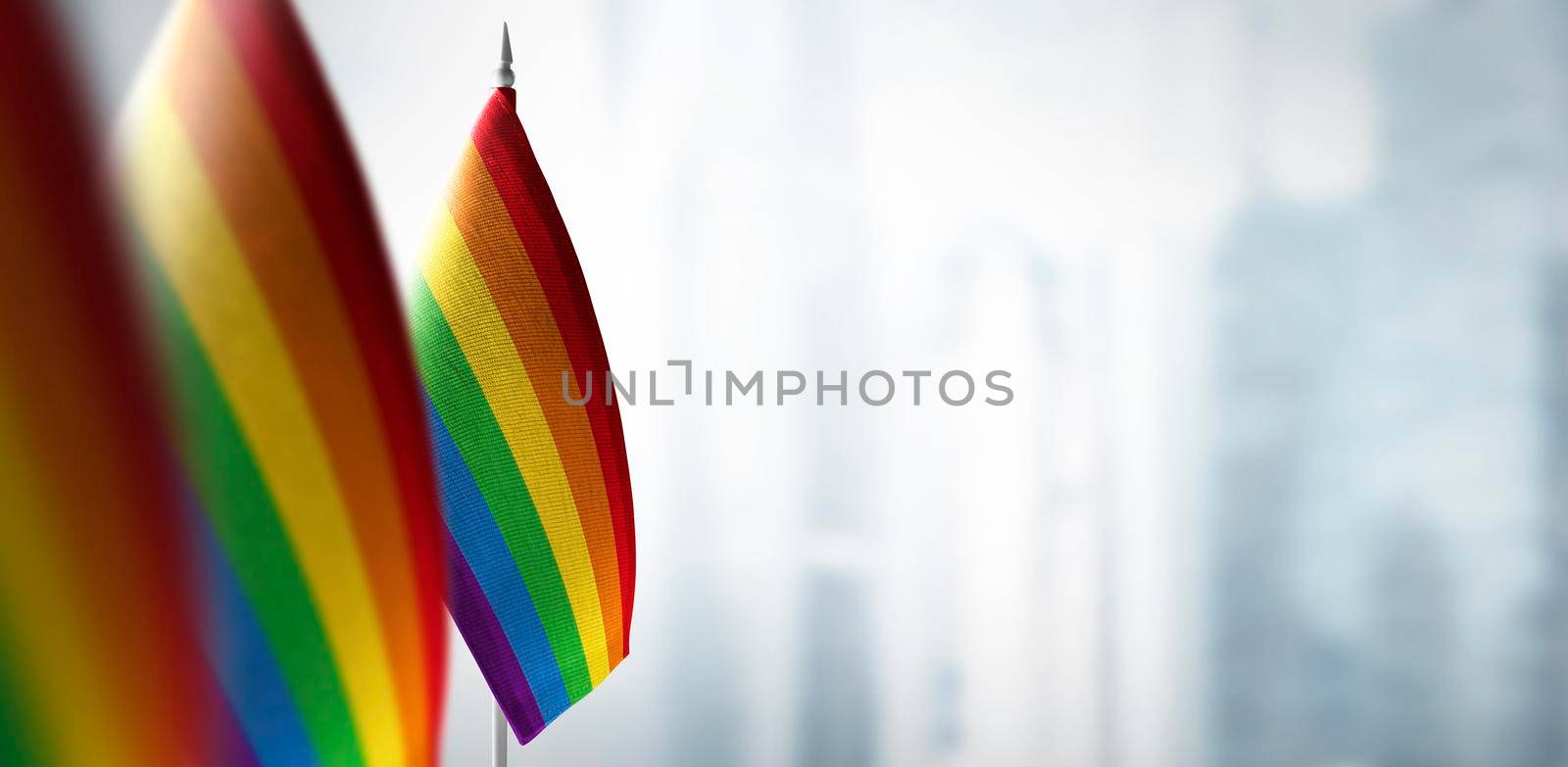 Small flags of lgbt on a blurry background of the city.