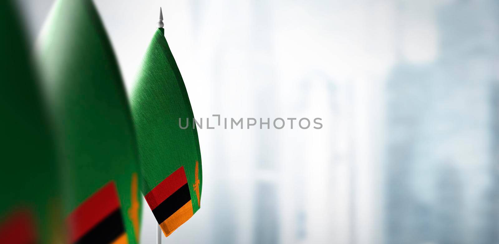 Small flags of Zambia on a blurry background of the city.