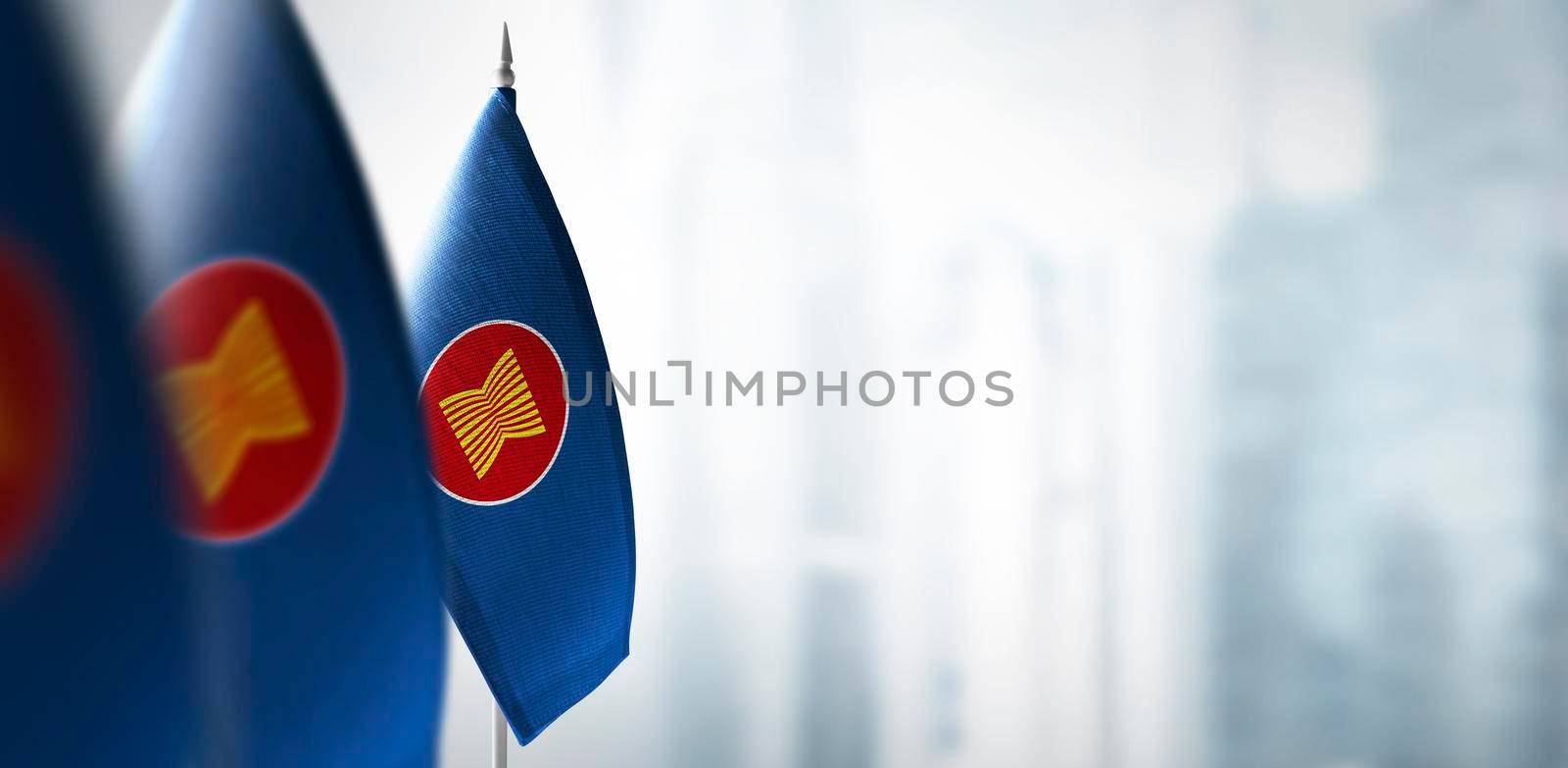 Small flags of ASEAN on a blurry background of the city by butenkow