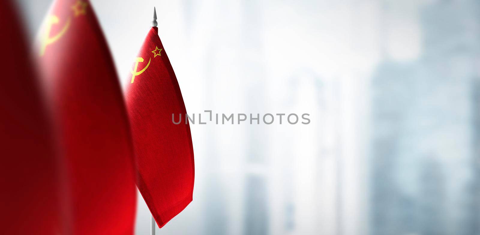 Small flags of USSR on a blurry background of the city.