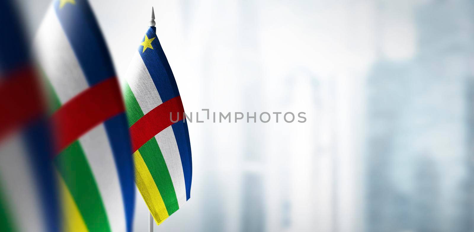 Small flags of Central African Republic on a blurry background of the city.