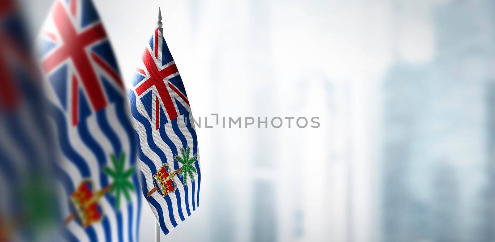 Small flags of British Indian Ocean Territory on a blurry background of the city.