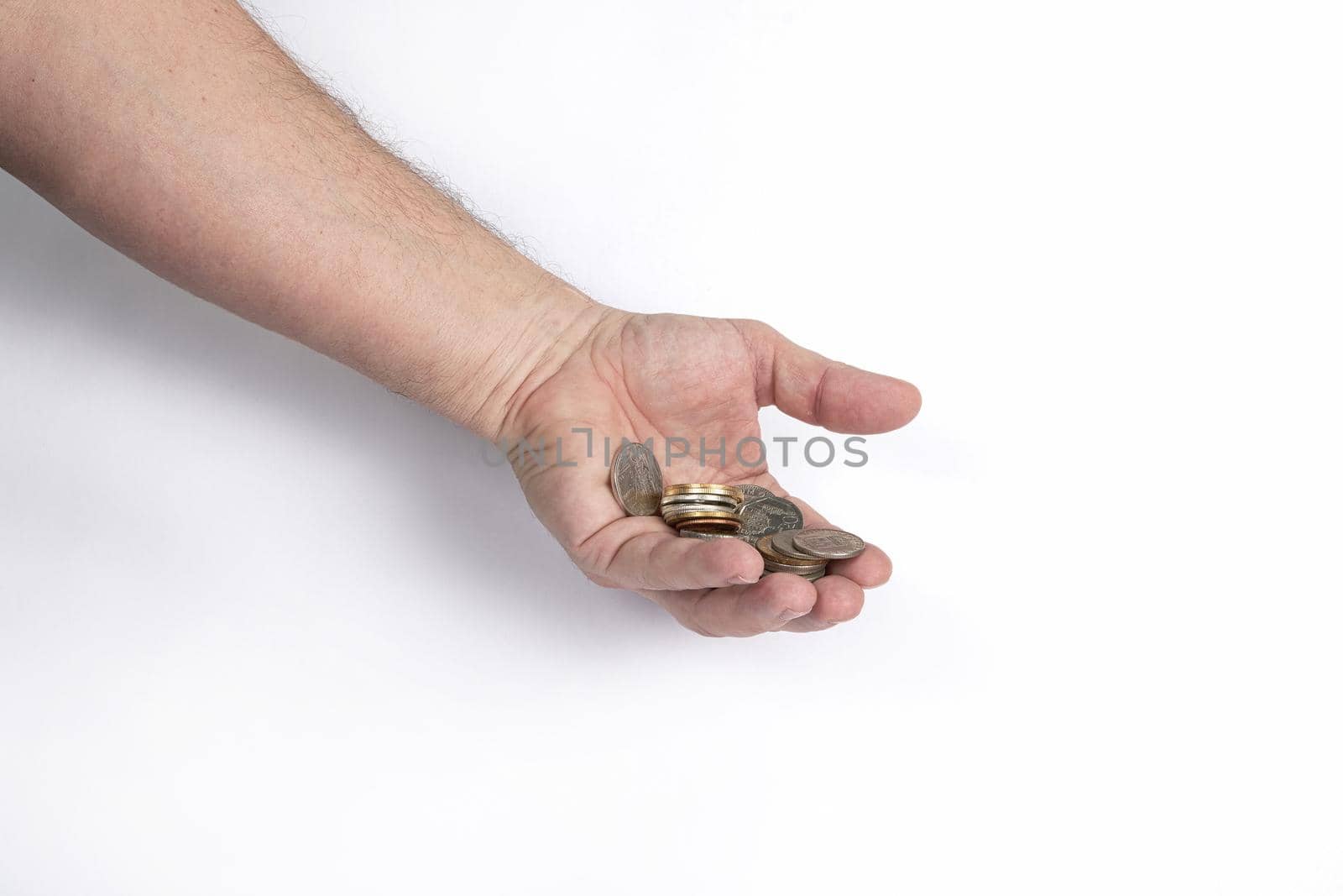 Hand holds a handful of coins on a white background, template for designers. Close up