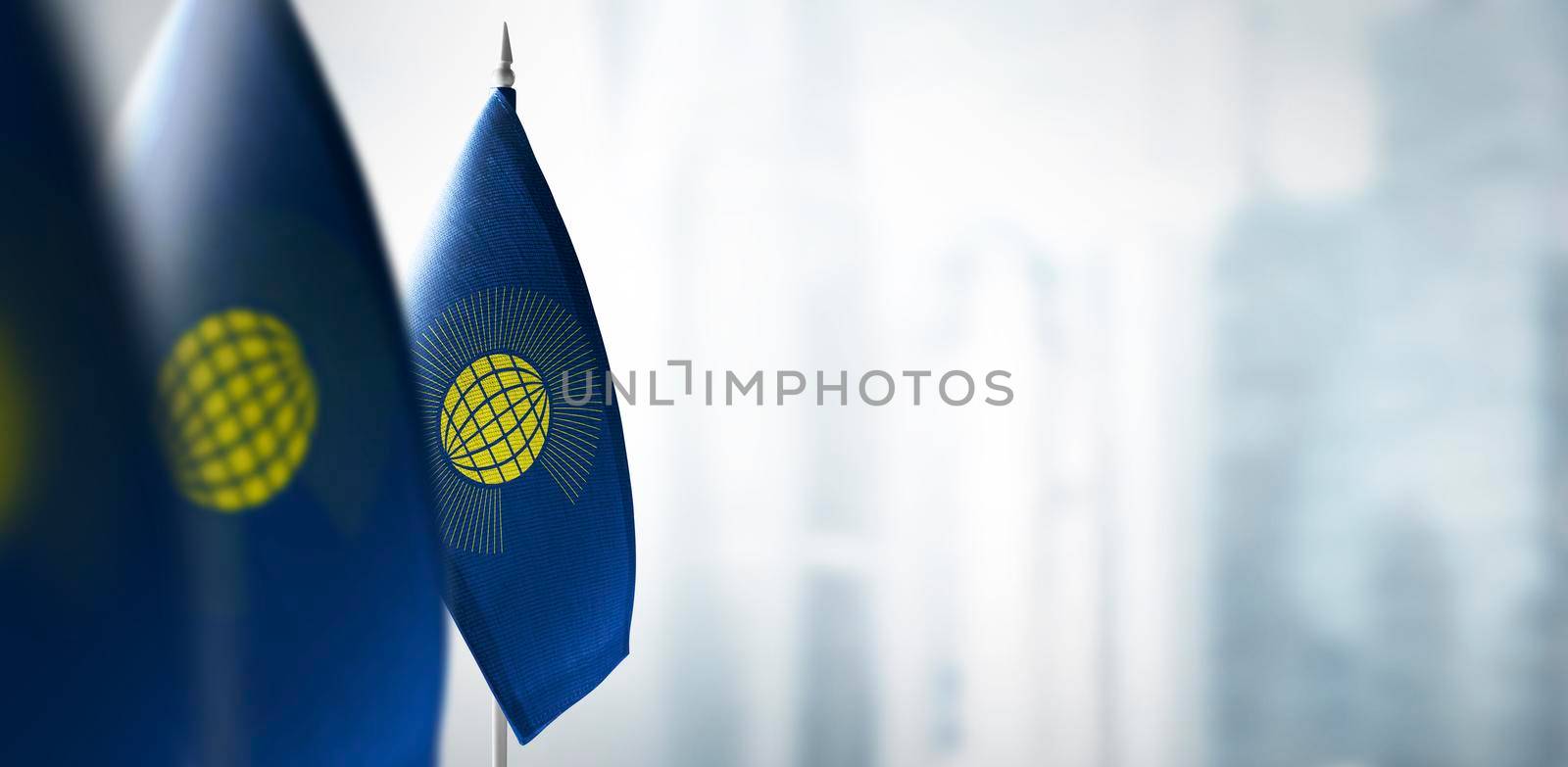 Small flags of Commonwealth on a blurry background of the city.