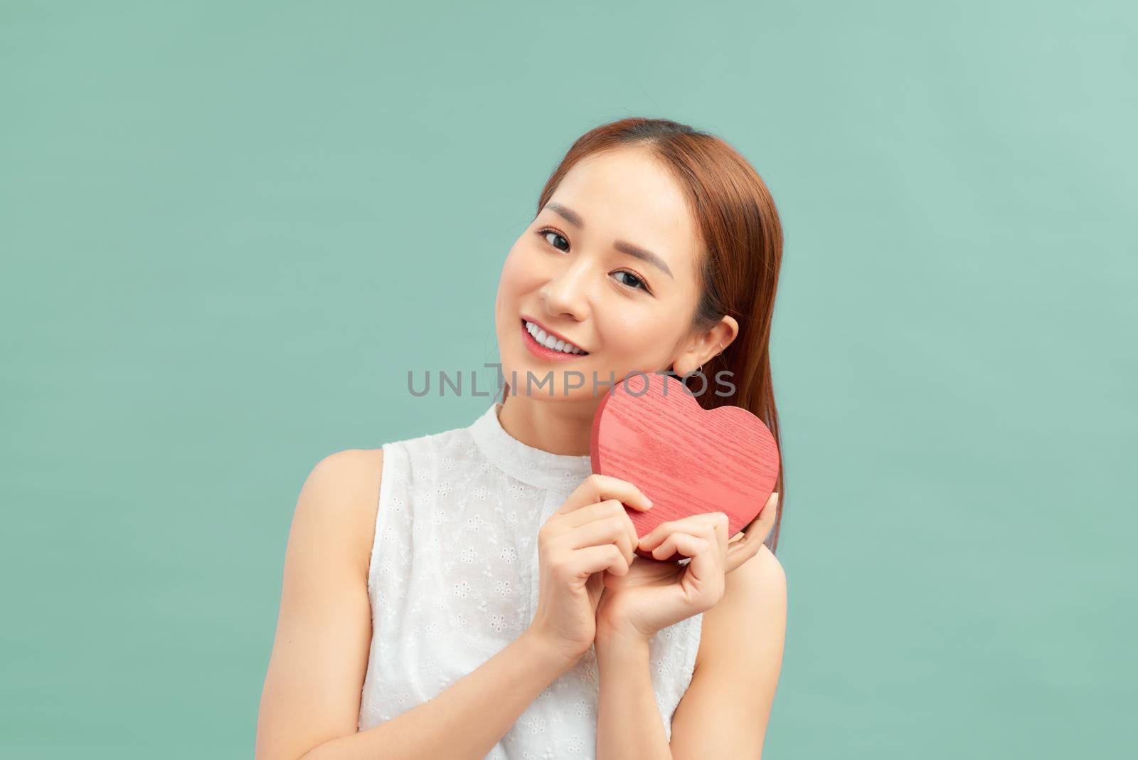 happiness, love and health concept - smiling asian woman with red heart