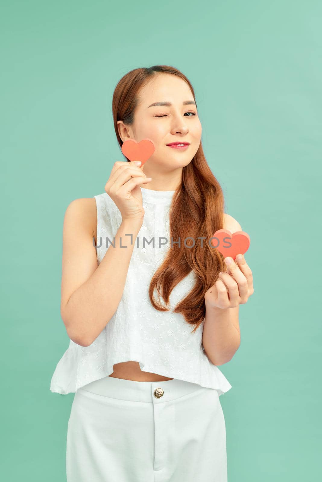 Beautiful and cheerful girl holding a paper red hearts by makidotvn