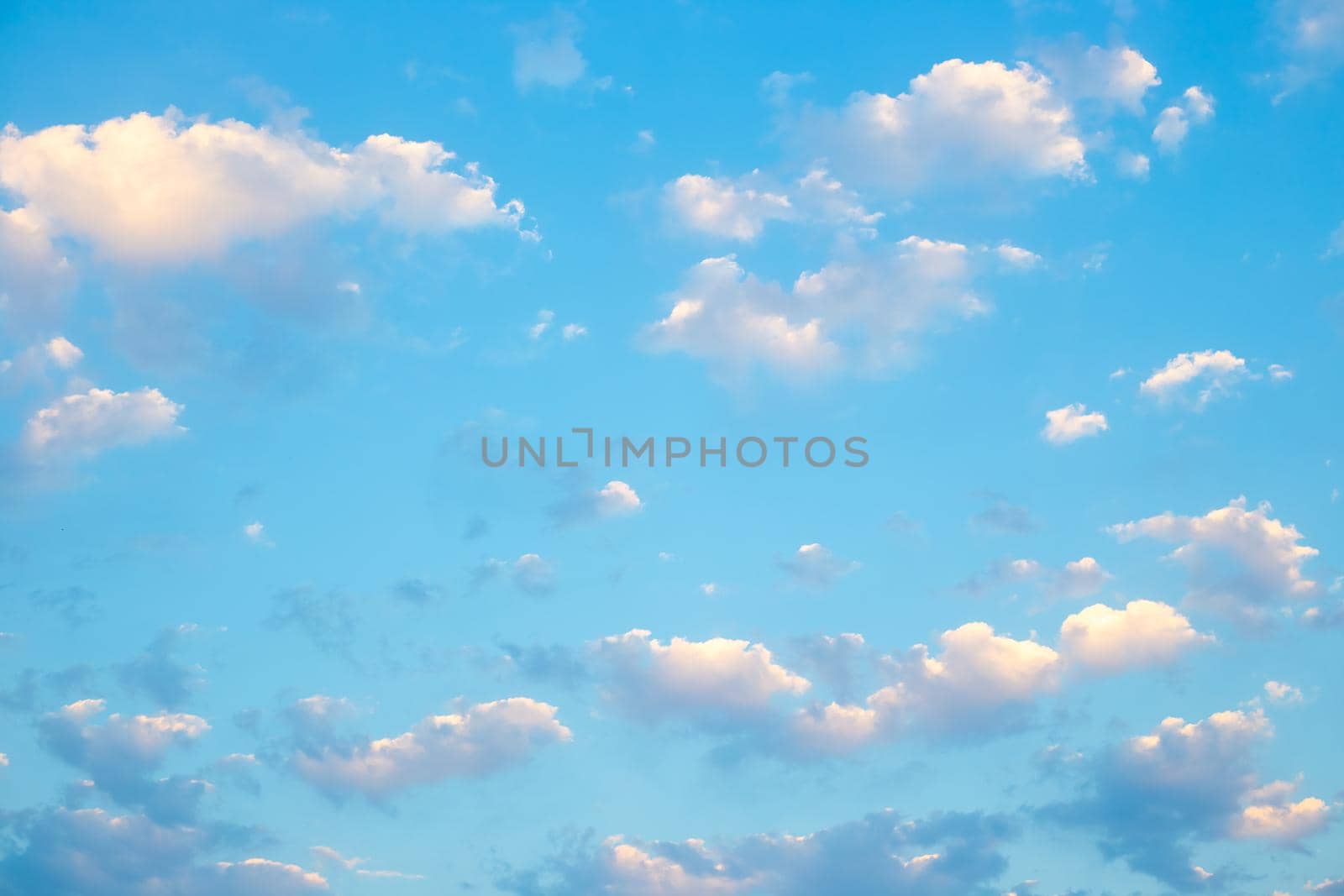 Blue sky with white sun-lit clouds. Natural airy background, pattern, texture by levnat09