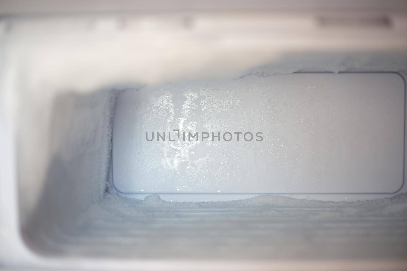 Frozen fridge freezer with ice. Household appliances care.