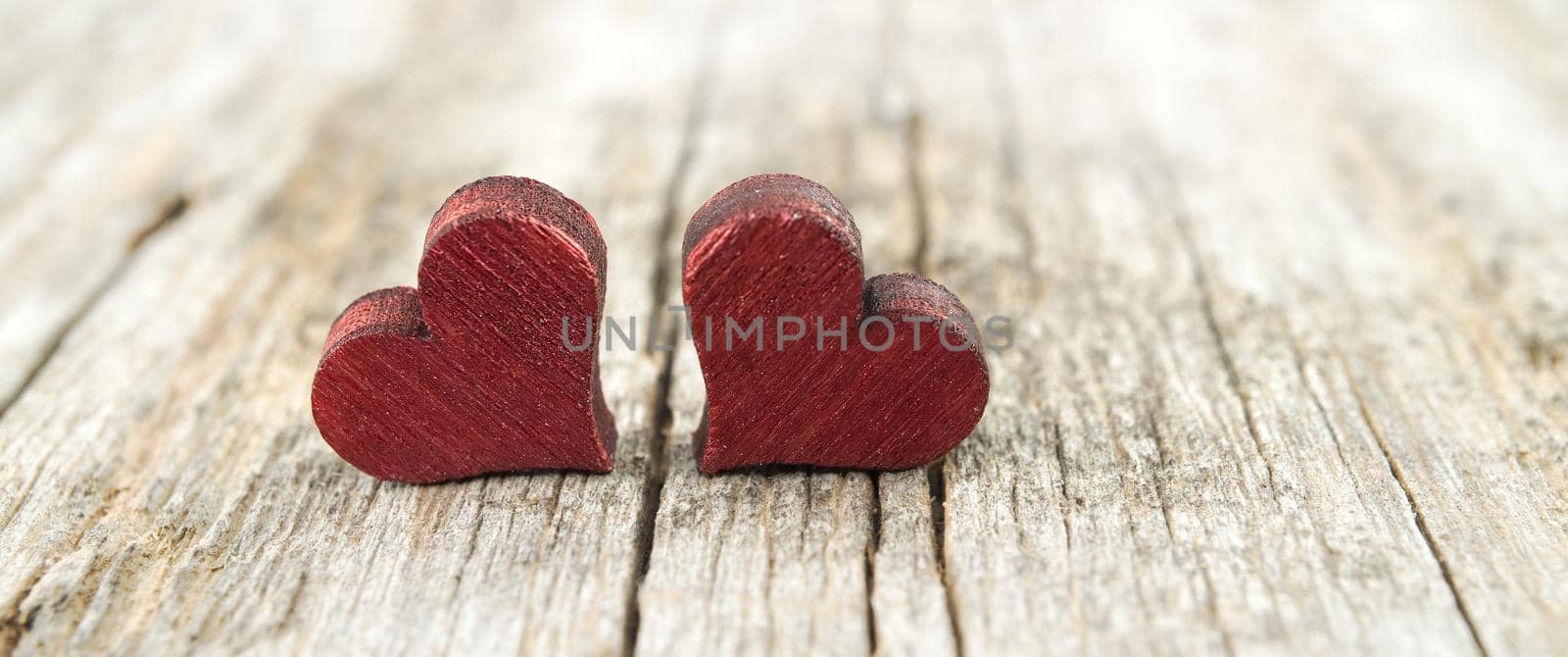 Two wooden hearts on the cracked rustic wooden table