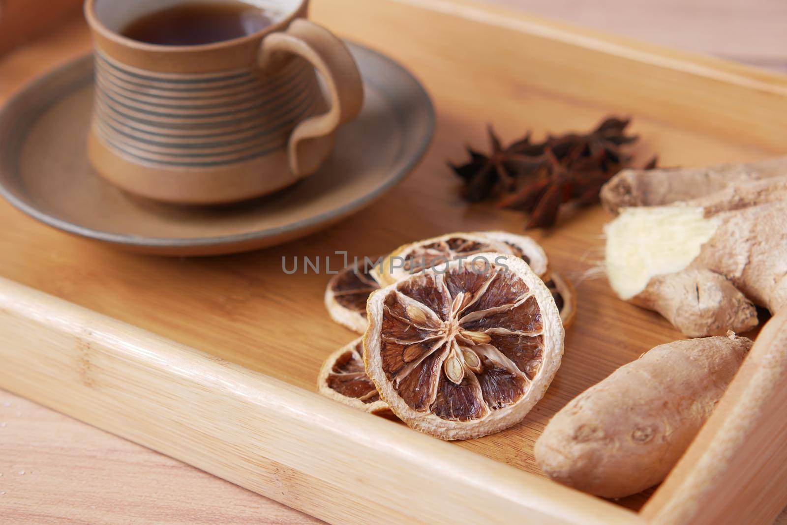 close up of dry lemon, ginger and green tea on table .