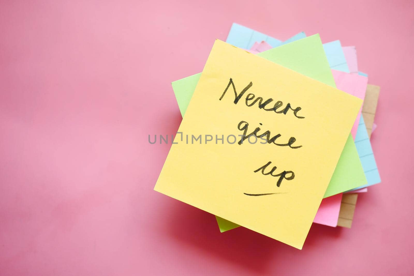 never give up word on stick note on table