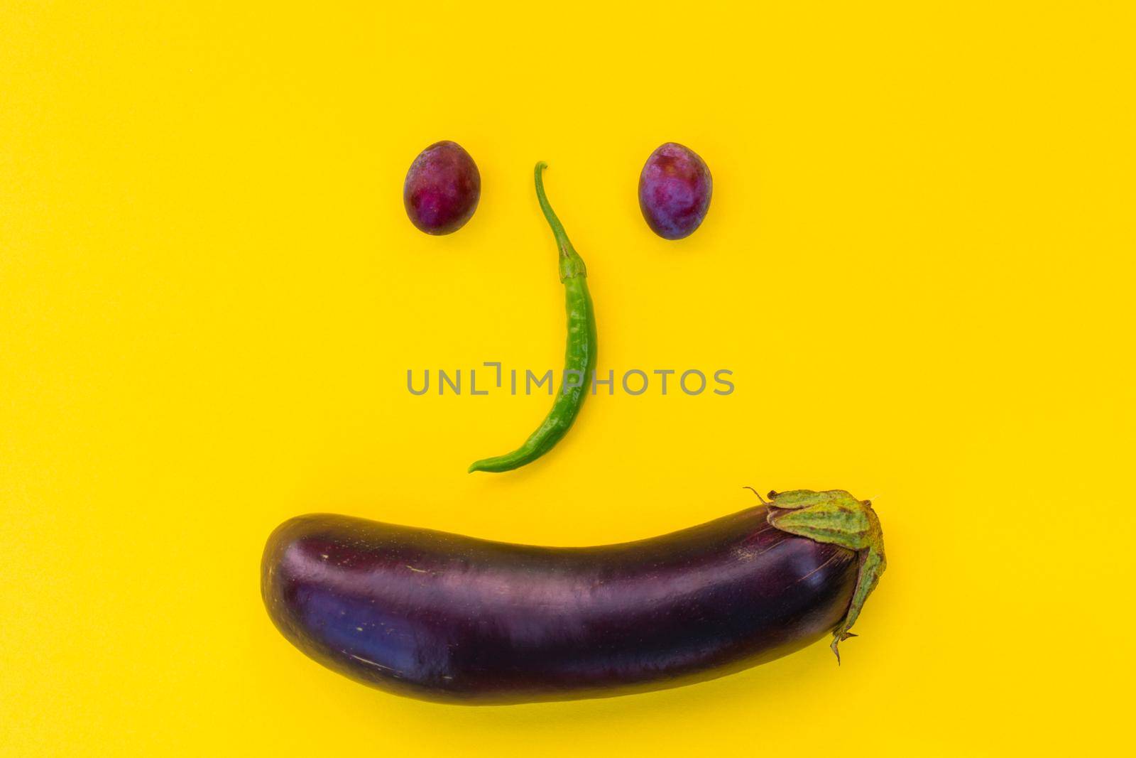 Autumn vegetables and fruits on a yellow background in the form of a muzzle. Minimalistic template, flat lay.