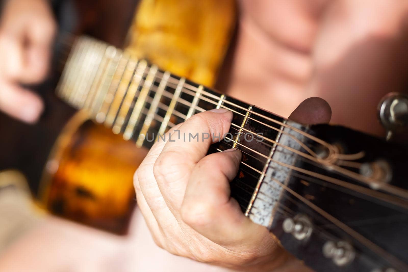 A man plays a twelve-string acoustic guitar. Hobbies and entertainment.