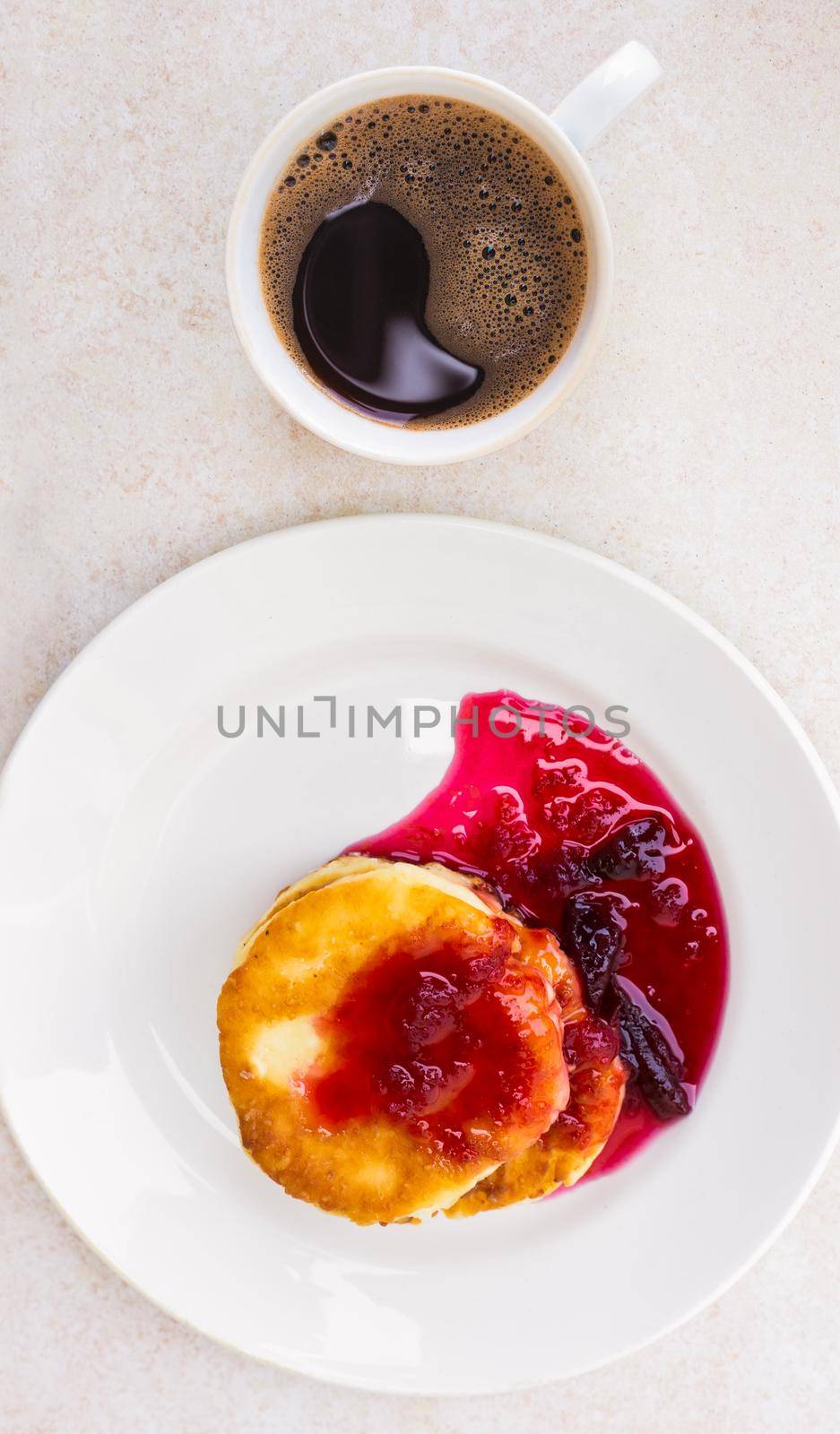 Fresh cheese cakes with plum jam and a mug with freshly brewed coffee on a light table surface, top view. Wake up in the morning, start a new day. Hearty breakfast by levnat09