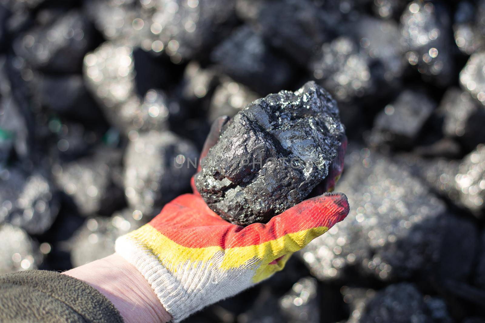 A piece of coal in a man's hand. Fossil fuels for home heating by levnat09