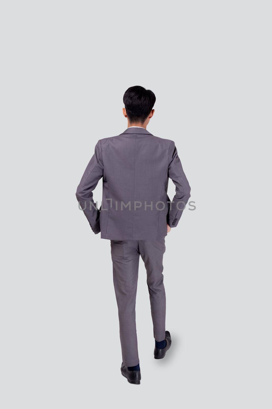 Back view young asian business man in suit walking isolated on white background, portrait of executive or manager, happy businessman handsome and smart, male with confident for success in studio.