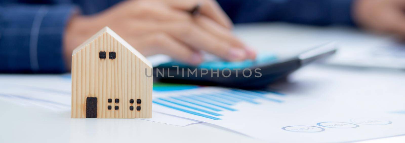 Hand of business man agent calculating loan of finance and investment for real estate, businessman and invest in property about home, construction or mortgage of home, male using calculator.