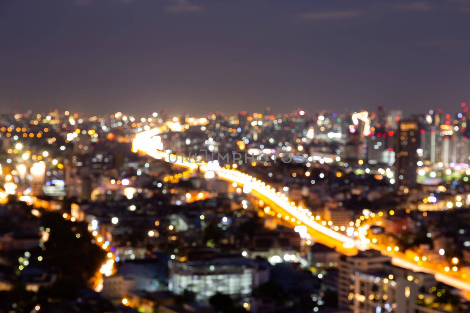 Blur bokeh background with cityscape in twilight, blurred focus in evening with downtown, landscape, illuminated and light.