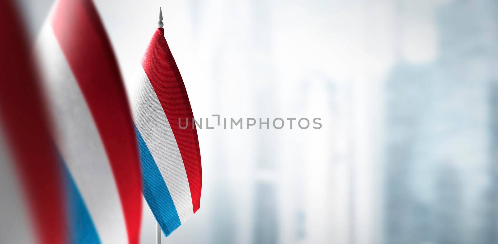 Small flags of Luxembourg on a blurry background of the city.