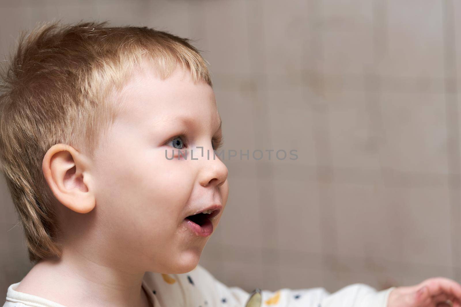 Head portrait of a little boy with a stained mouth and emotion on his face