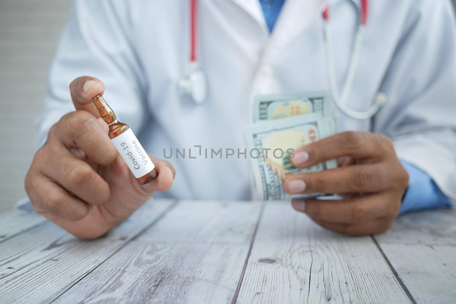 doctor hand hold corona vaccine and us dollar .