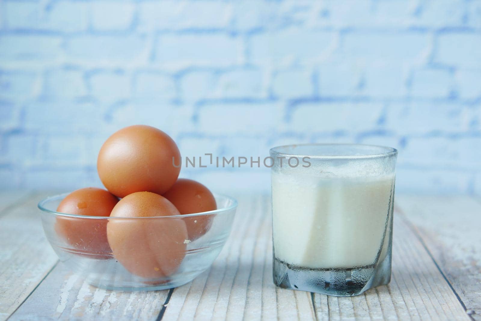 eggs in a bow and a glass of milk on table ,