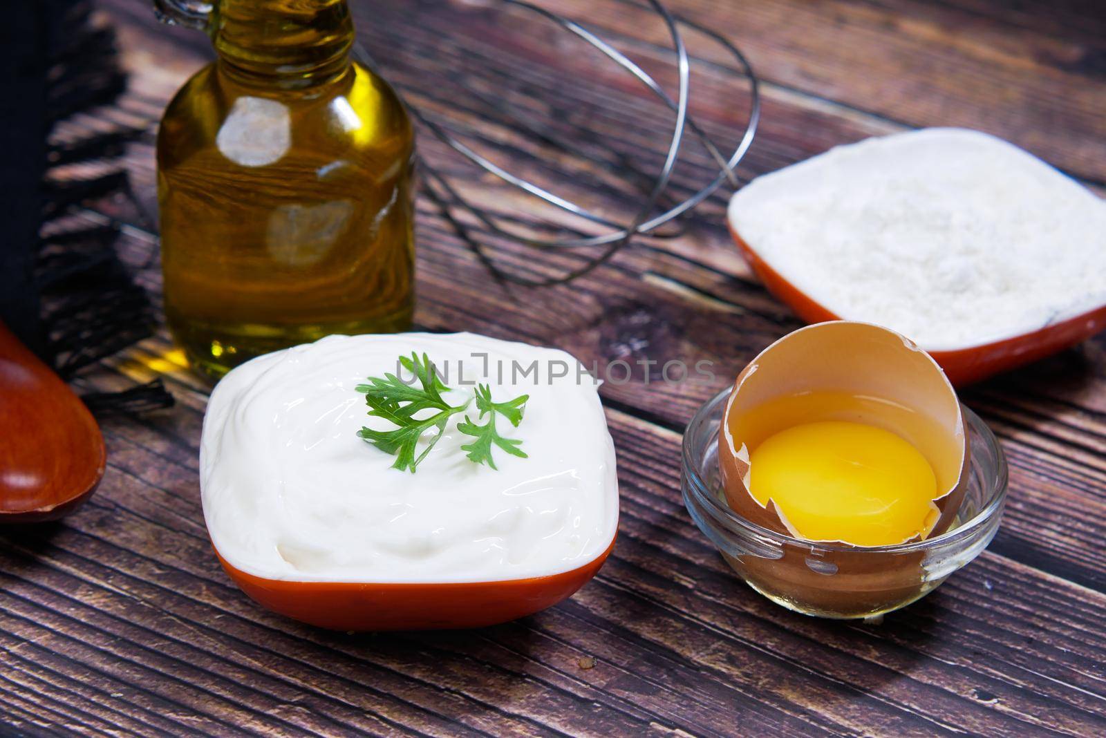 Mayonnaise in container , oil and eggs on table ,