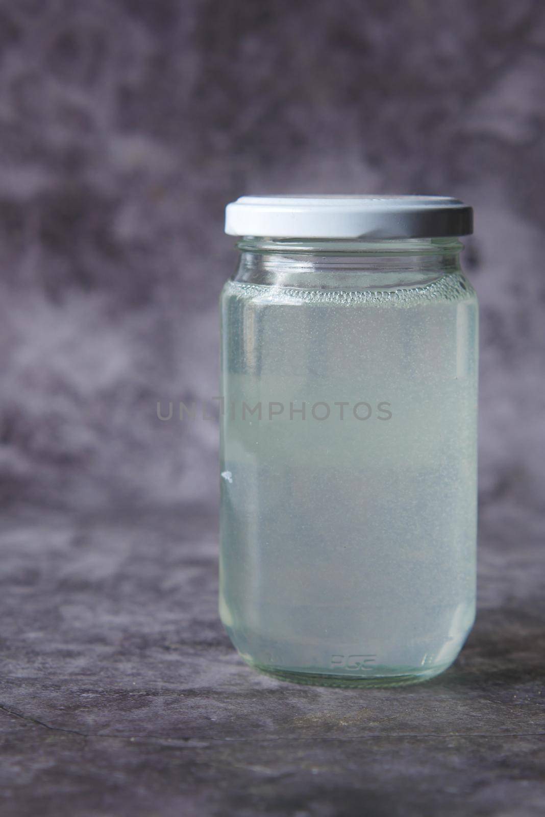 coconut oil in a glass jar on black background .