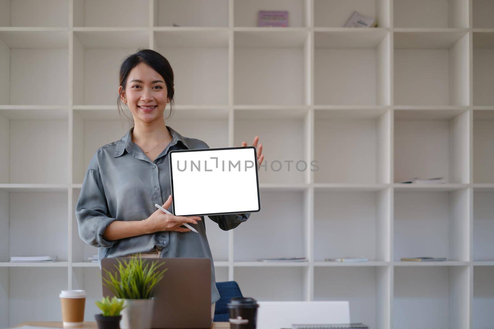 A Woman excited surprise and showing digital tablet white screen. Blank screen for your advertising. by itchaznong