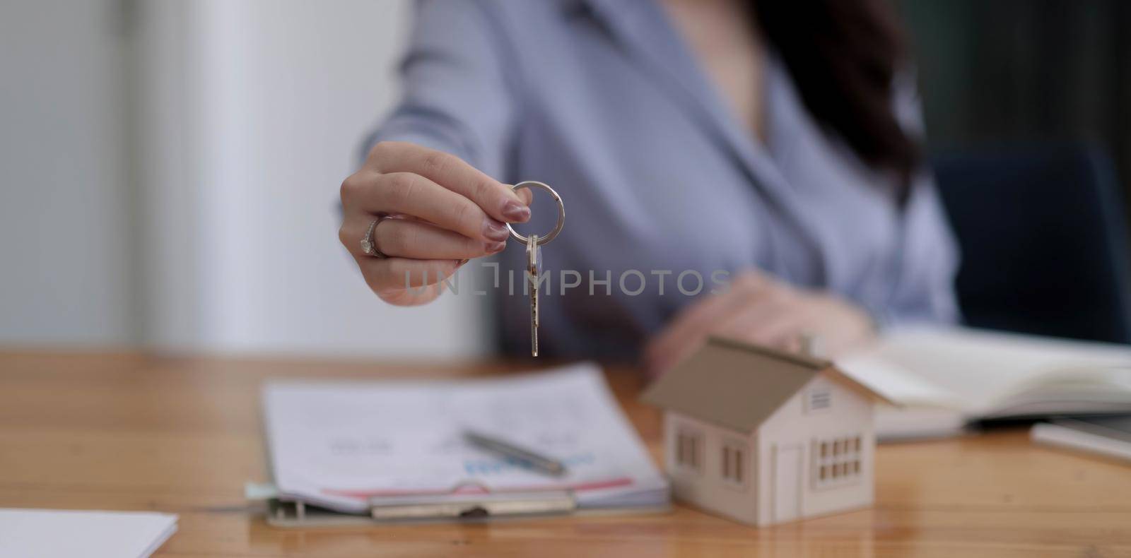 House key in home insurance broker agent's hand protection or in salesman person giving to buyer customer owner by wichayada