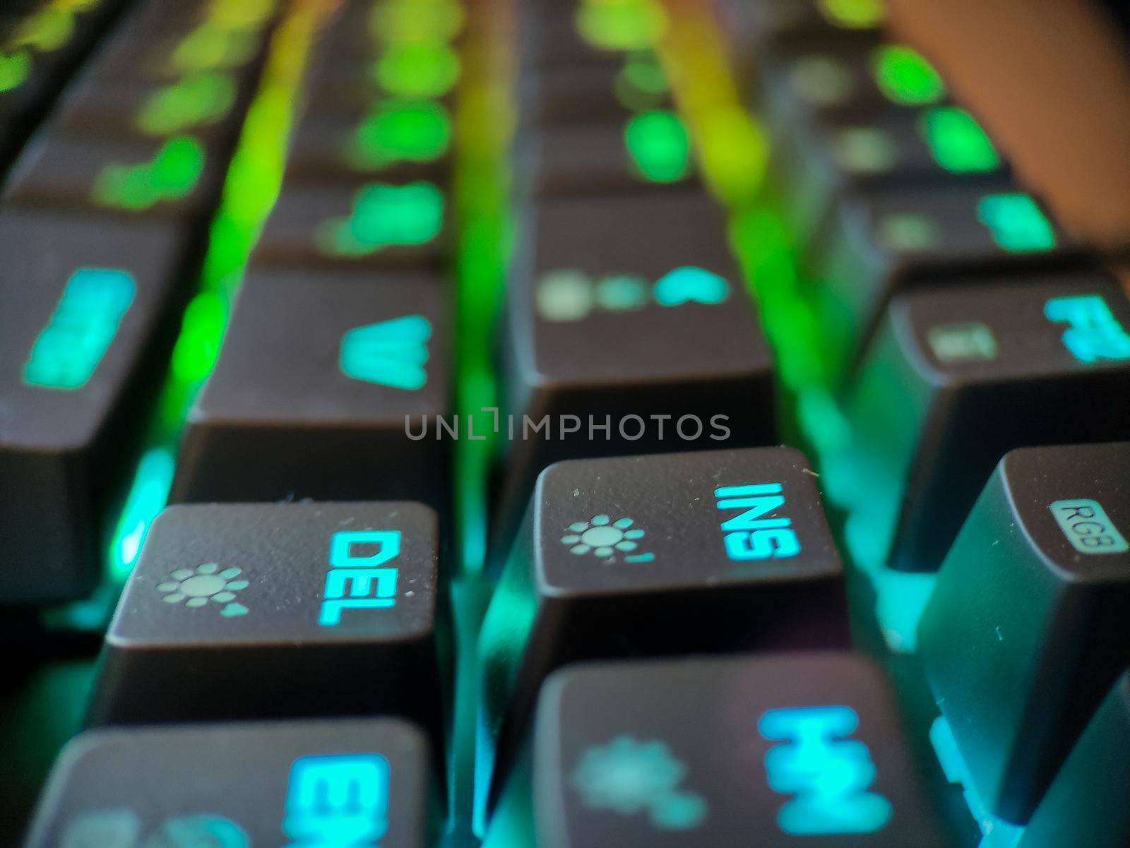 Gamer keyboard with neon backlight macro defocused close up. Online games and virtual reality concept background. High quality photo